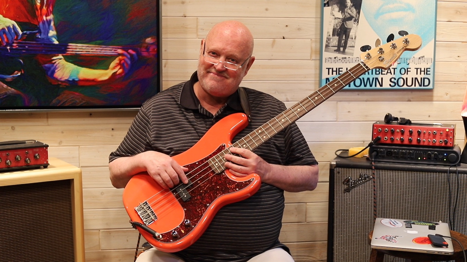 Jim Stinnett in his studio with a red bass